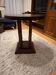 1930s Art Deco round side table in brown wood — circular top and turned legs.