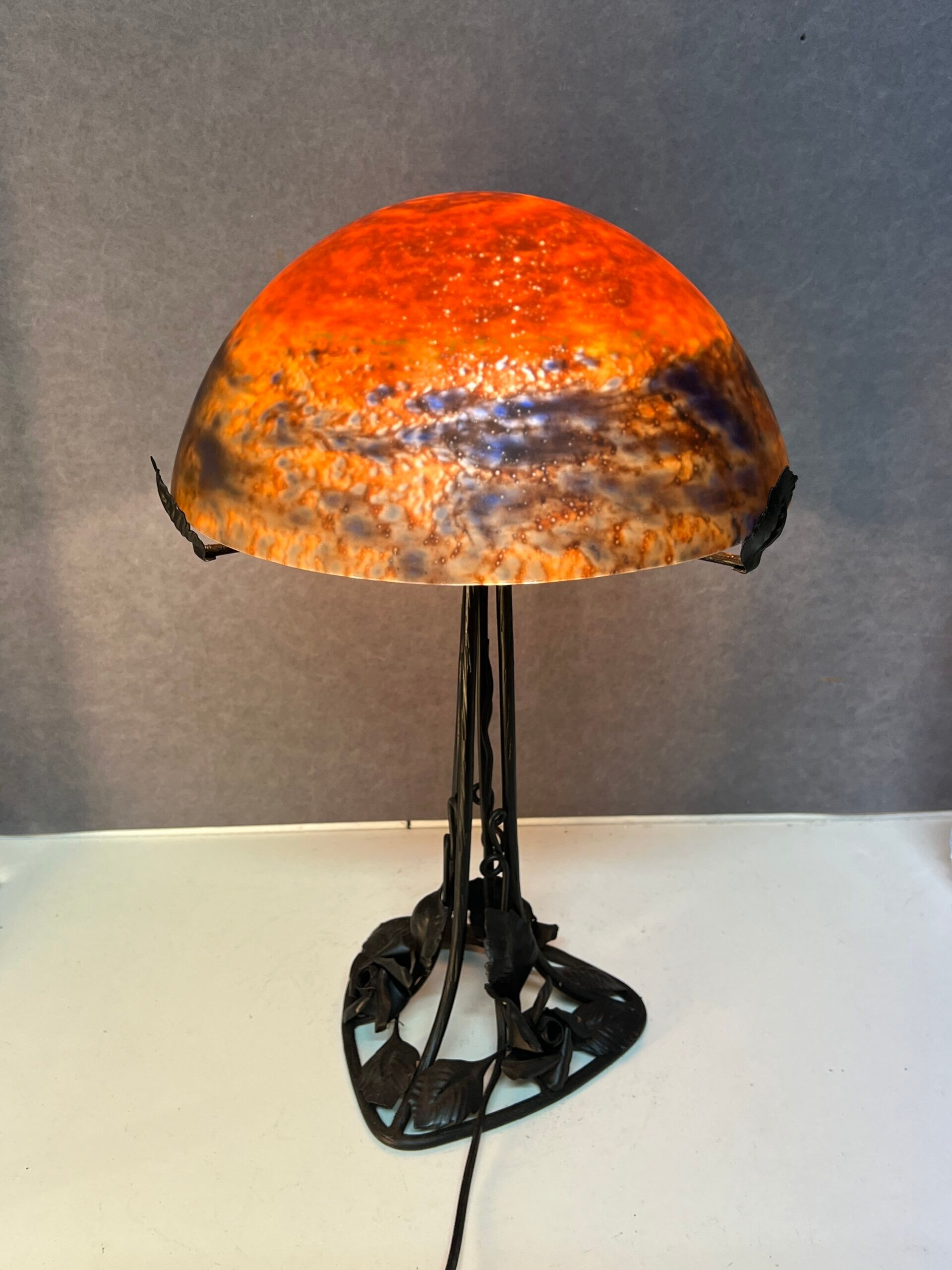 Contemporary mushroom lamp, wrought iron base and shaded orange glass shell