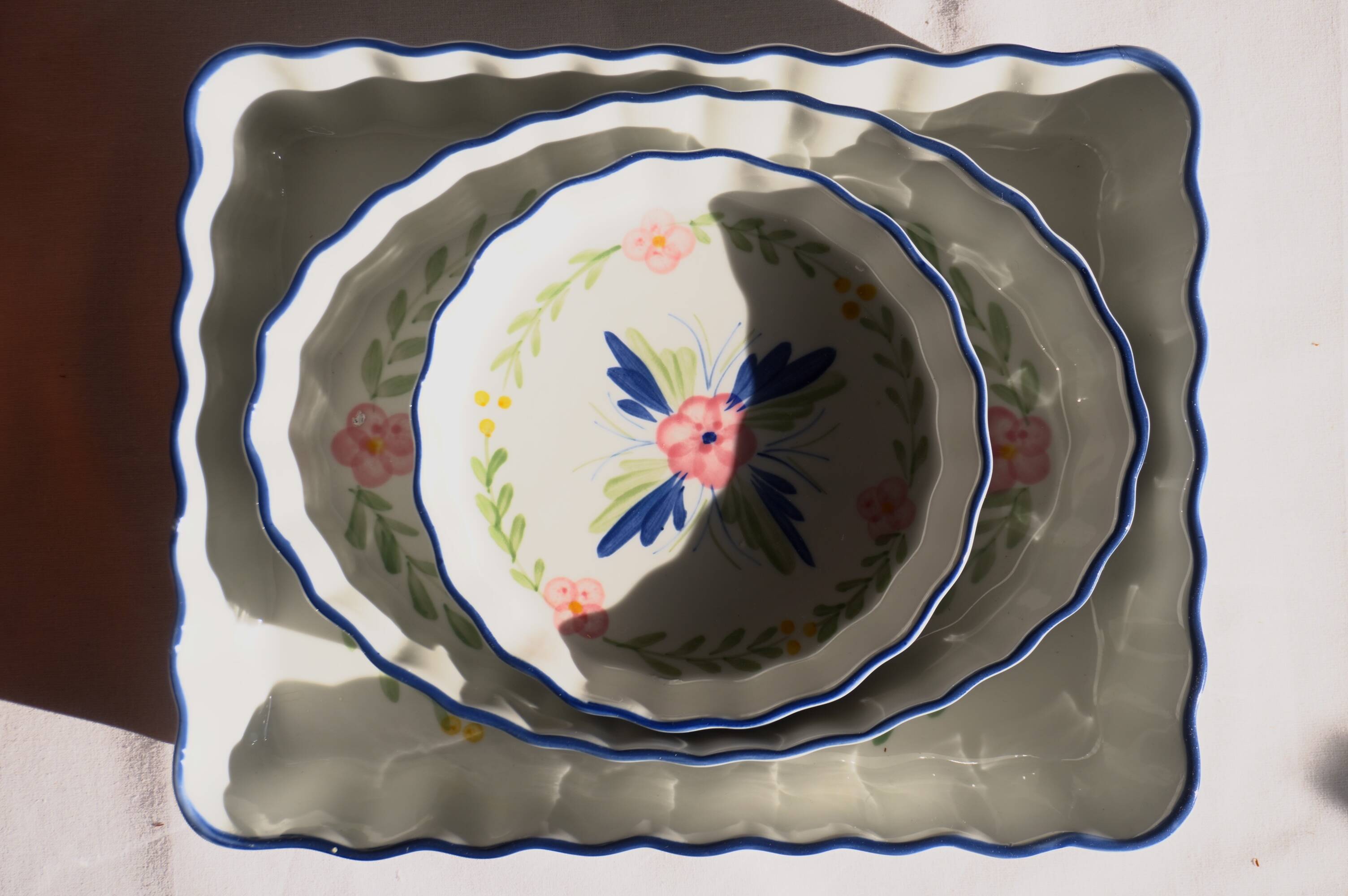 Set of 3 porcelain dishes with floral decorations, with wicker supports.