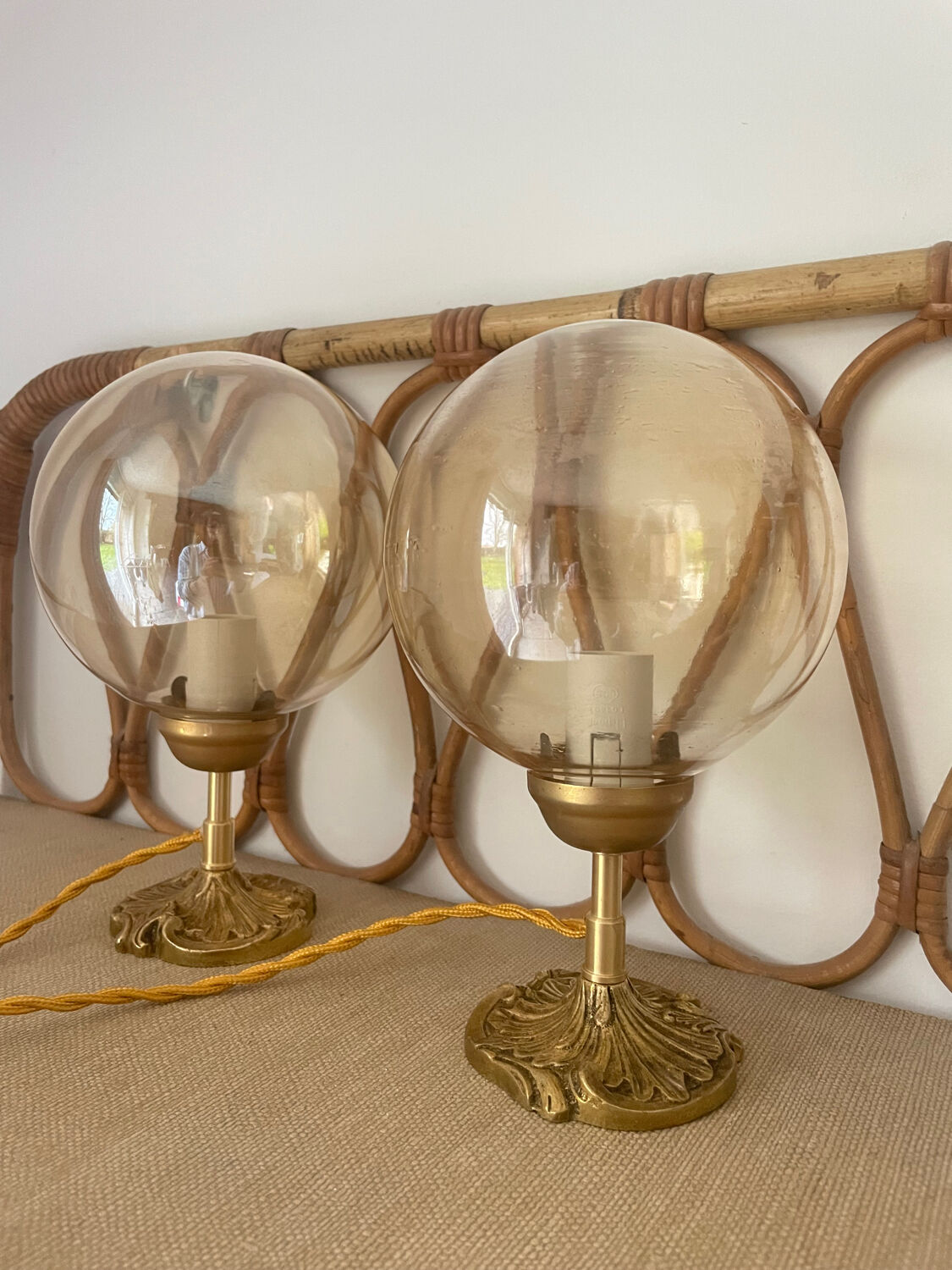 2 bedside lamps with round amber glass globes and gold metal.