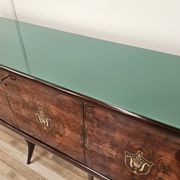 Mid-century mahogany buffet with teal glass and compartments with a drawer.