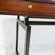 Wooden desk with drawers and black lacquered legs.