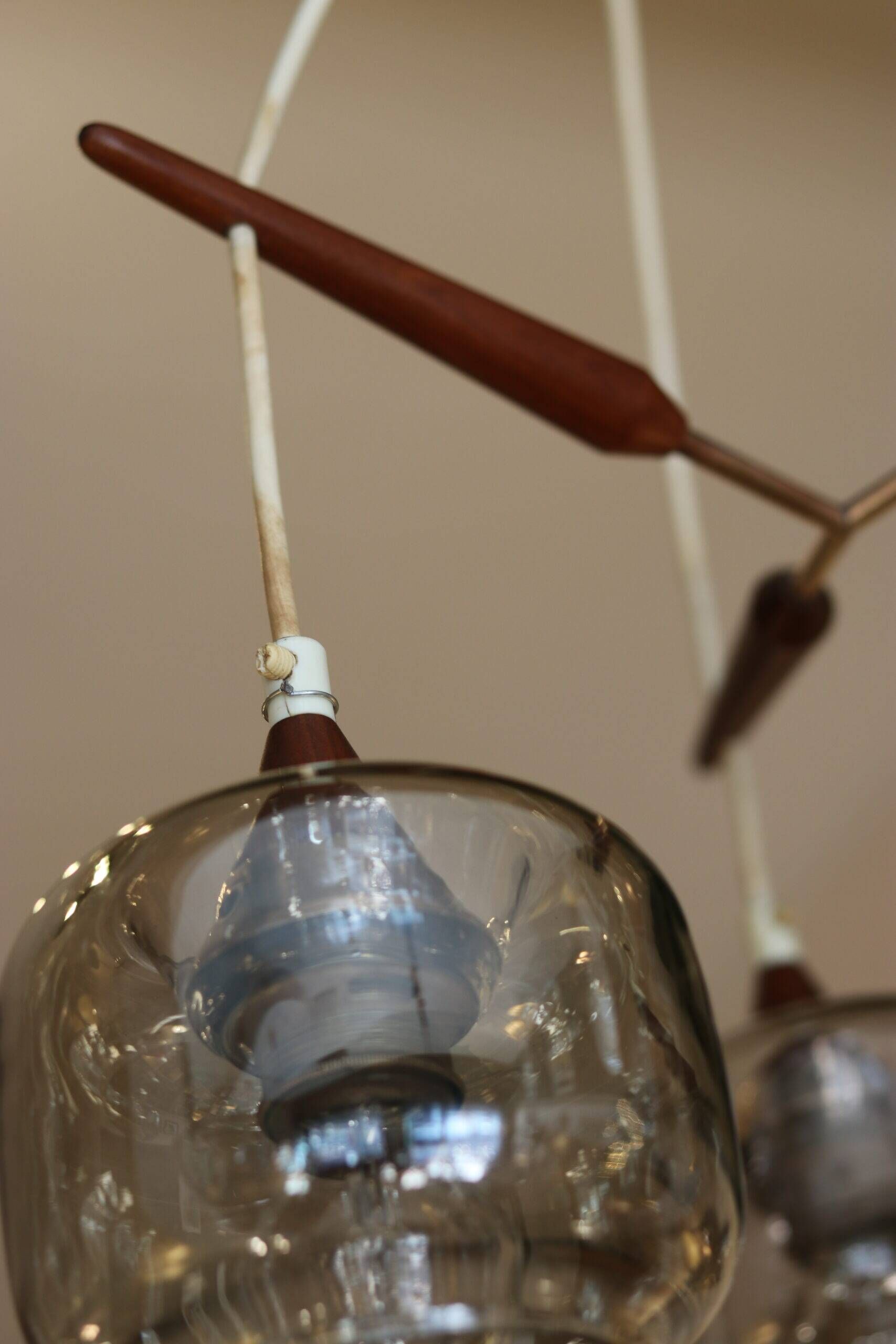 Scandinavian chandelier "Cascade" from the 1960s in brass, teak, and smoked glass.