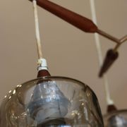 Scandinavian chandelier "Cascade" from the 1960s in brass, teak, and smoked glass.