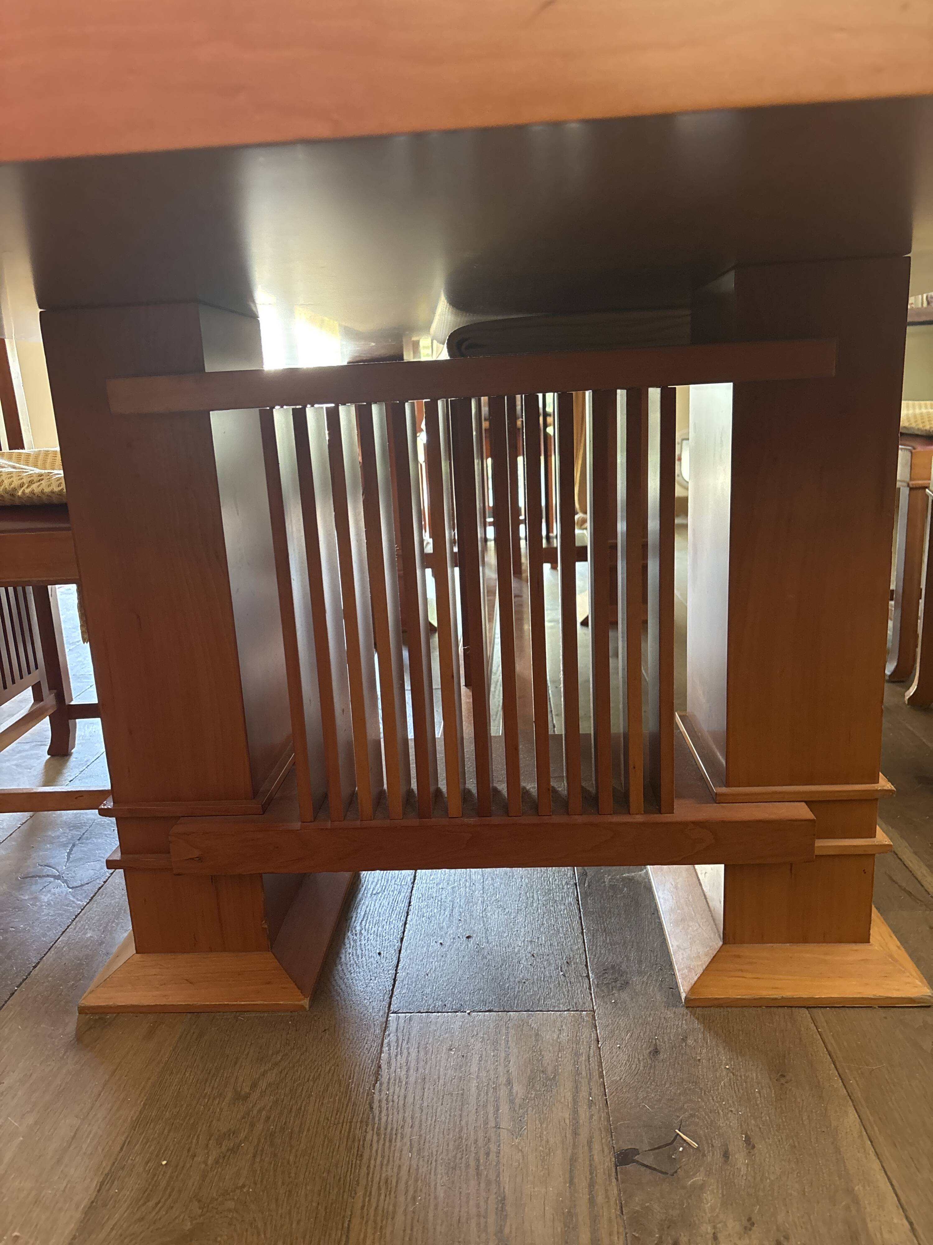 "Frank Lloyd Wright set with a table and its eight chairs."
