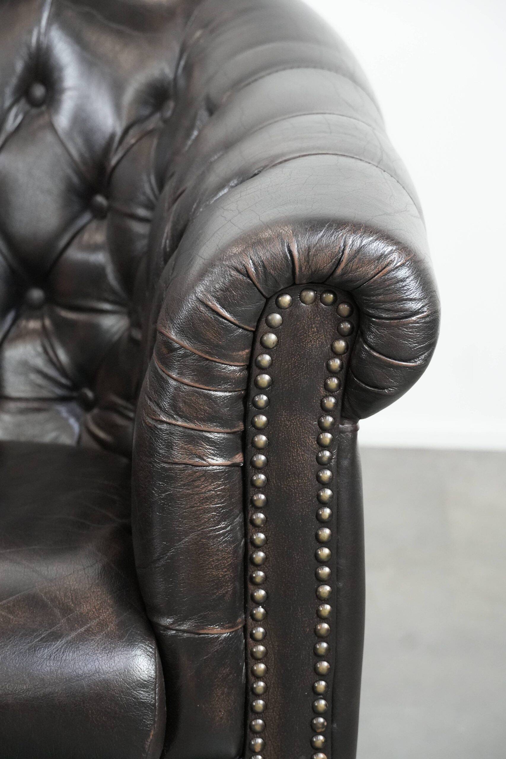 Ensemble de deux luxueux fauteuils club Chesterfield en cuir de vachette noir.