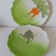 4 hand-decorated earthenware plates with vegetable and green leaf designs.