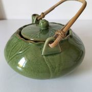 Vintage green teapot with lotus decoration and bamboo handle.