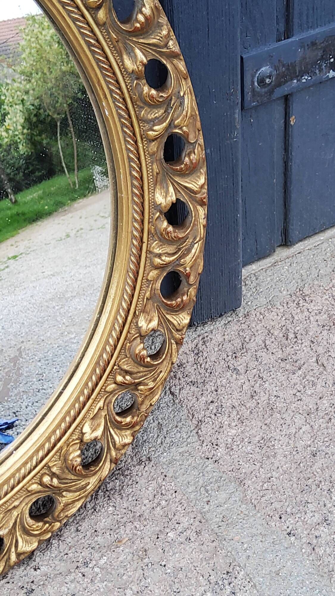 Round neoclassical style mirror in wood and gilded stucco from the 1950s