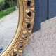 Round neoclassical style mirror in wood and gilded stucco from the 1950s