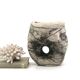 Ceramic vase sculpture decorated with faces and featuring a hole, 1980s.