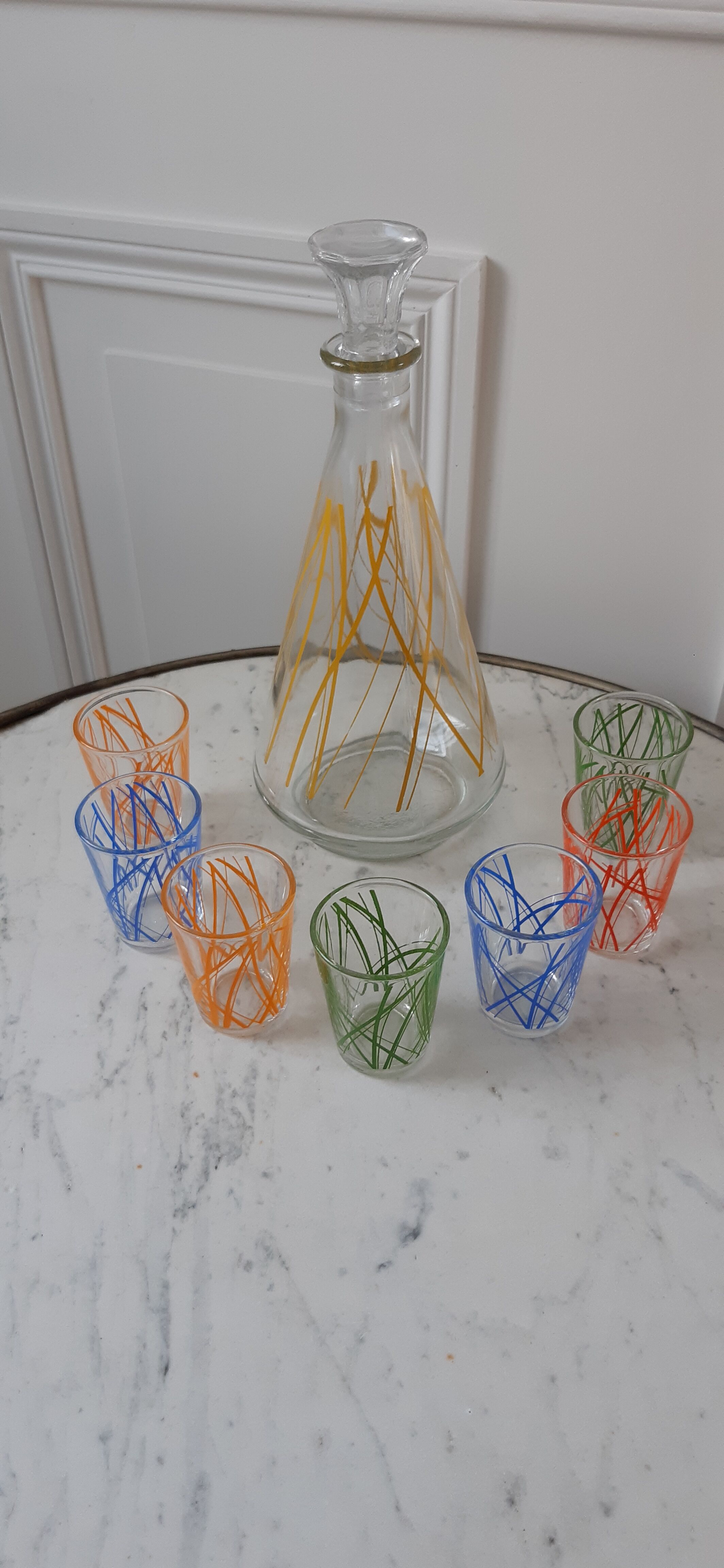 Colorful set consisting of a decanter and 7 70s liqueur glasses