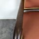 Restoration armchair in mahogany with cross arms and orange fabric.