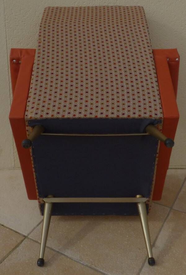 Vintage rockabilly retro armchair in orange faux leather and fabric.