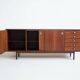Wooden sideboard with sliding door and white drawers, around 1960.