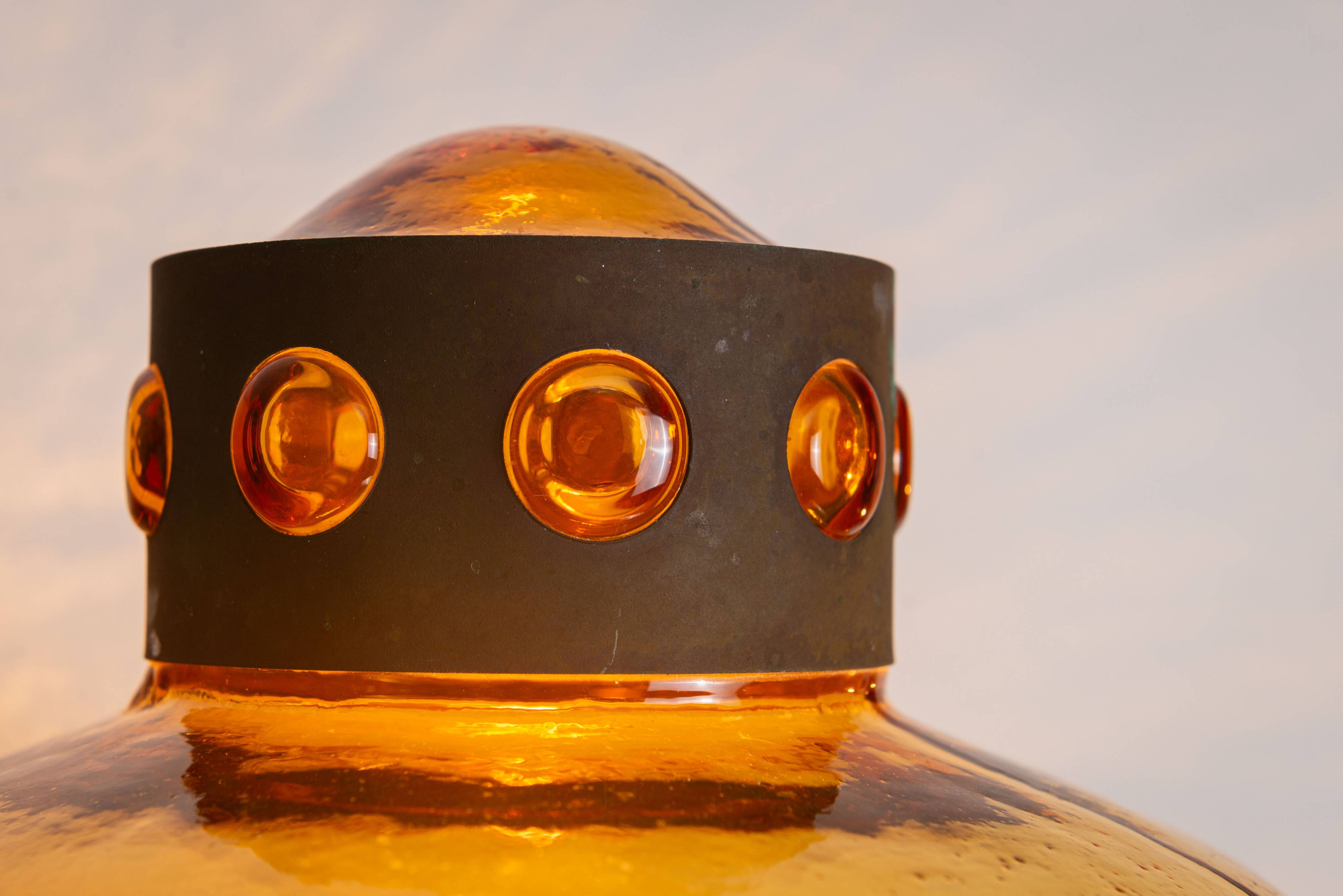 Pair of brass wall lamps with decorated amber coloured shades