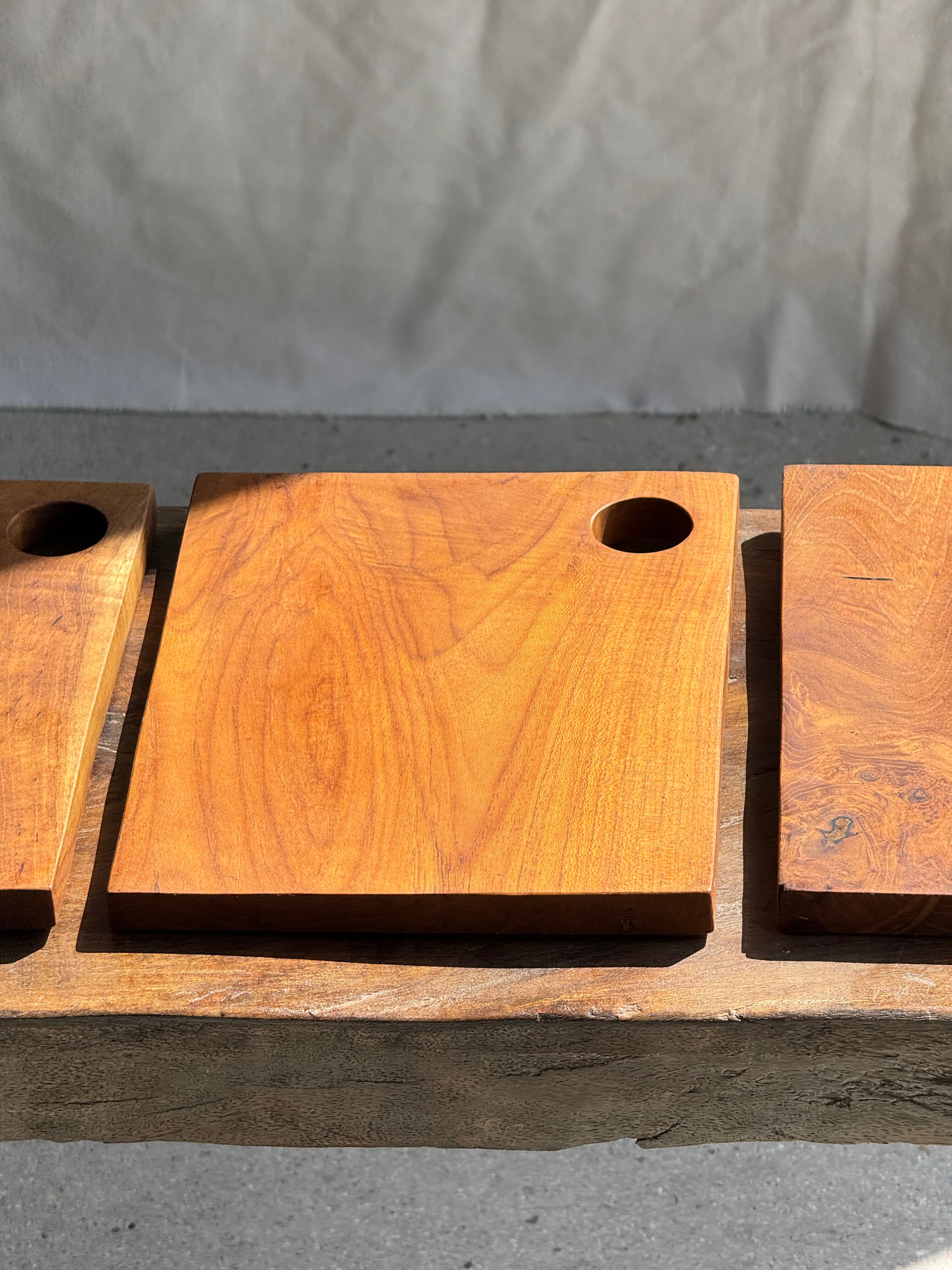Small rectangular teak monoxyle cutting board with a circular handle.