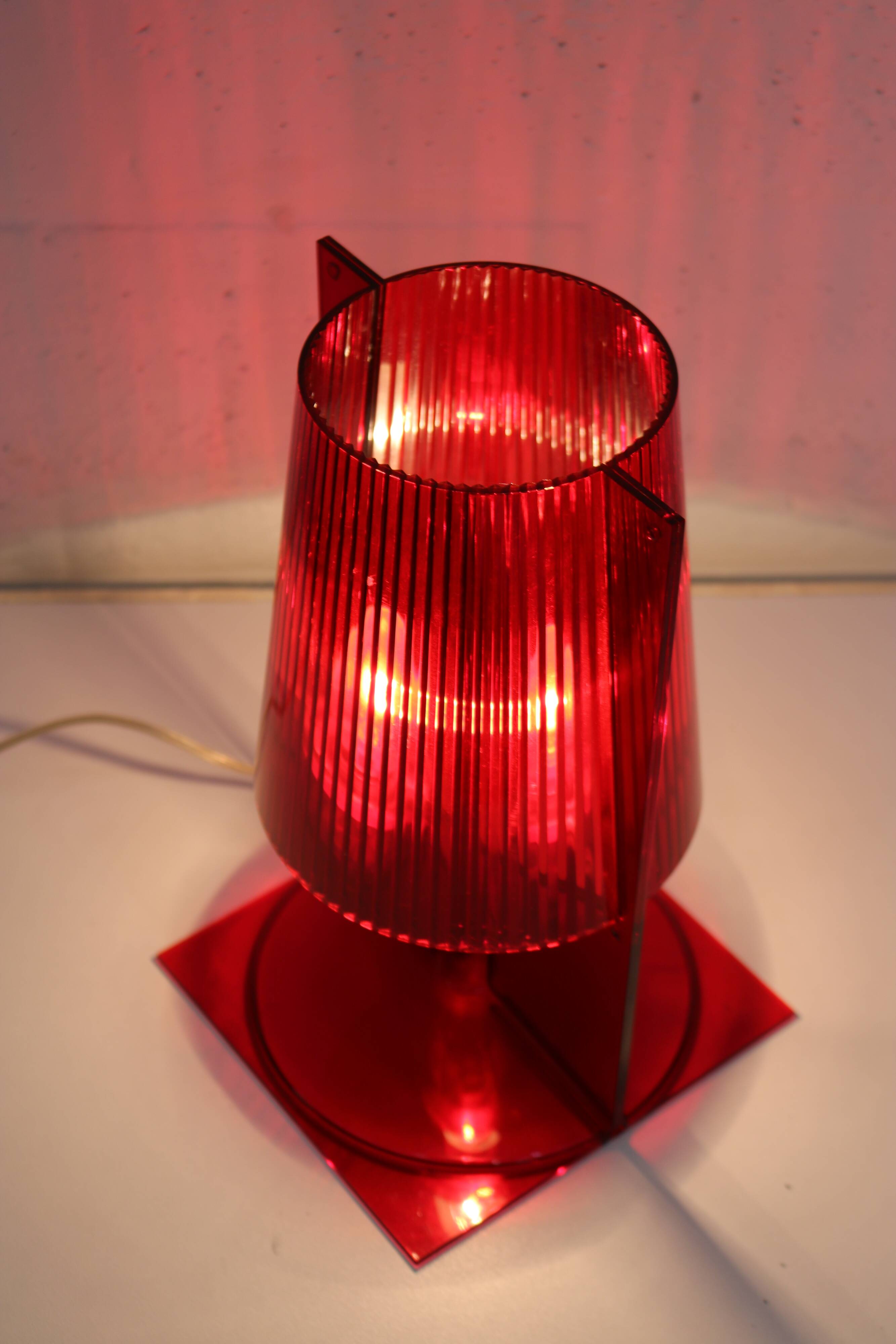 Red plastic Kartell table lamp - model Take - design by Ferruccio Laviani
