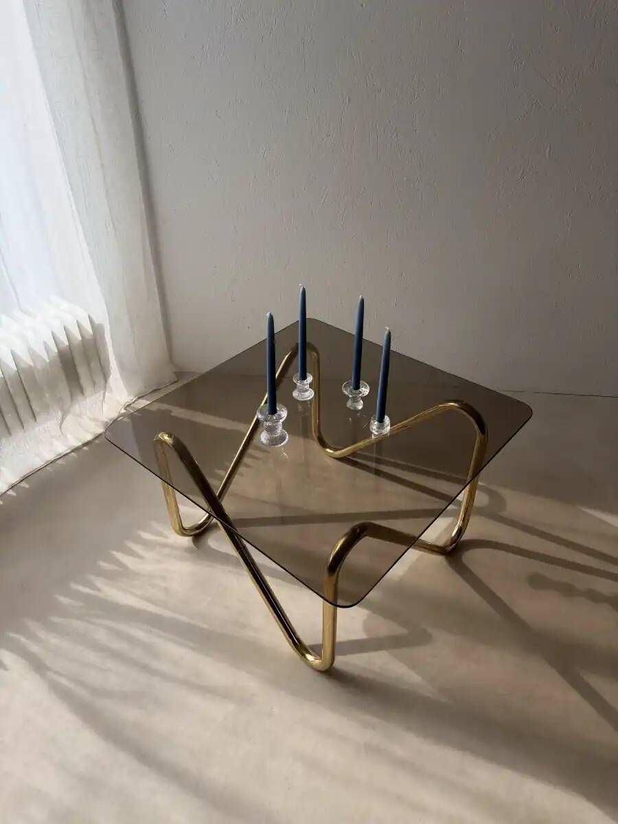 Coffee table with smoked glass and curved metal base