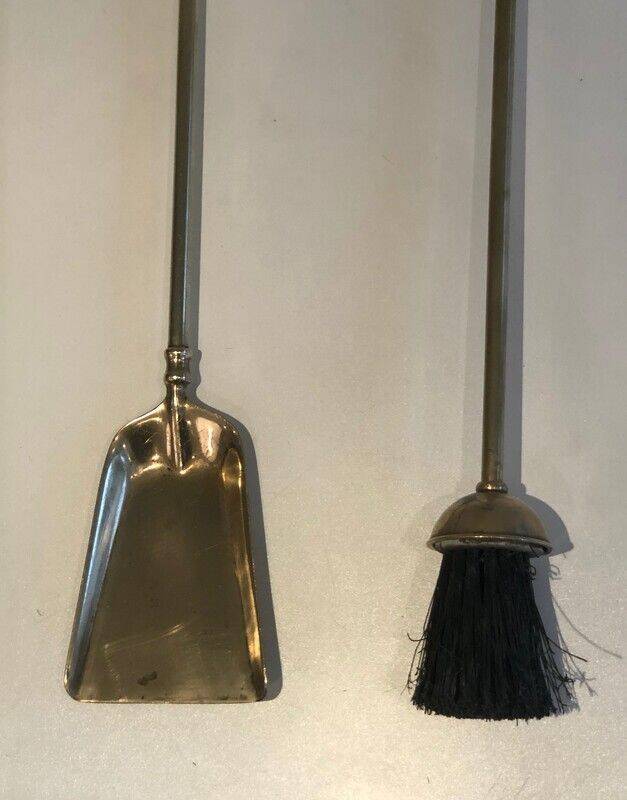 Neoclassical brass fire accessory with duck head decorations.