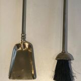 Neoclassical brass fire accessory with duck head decorations.