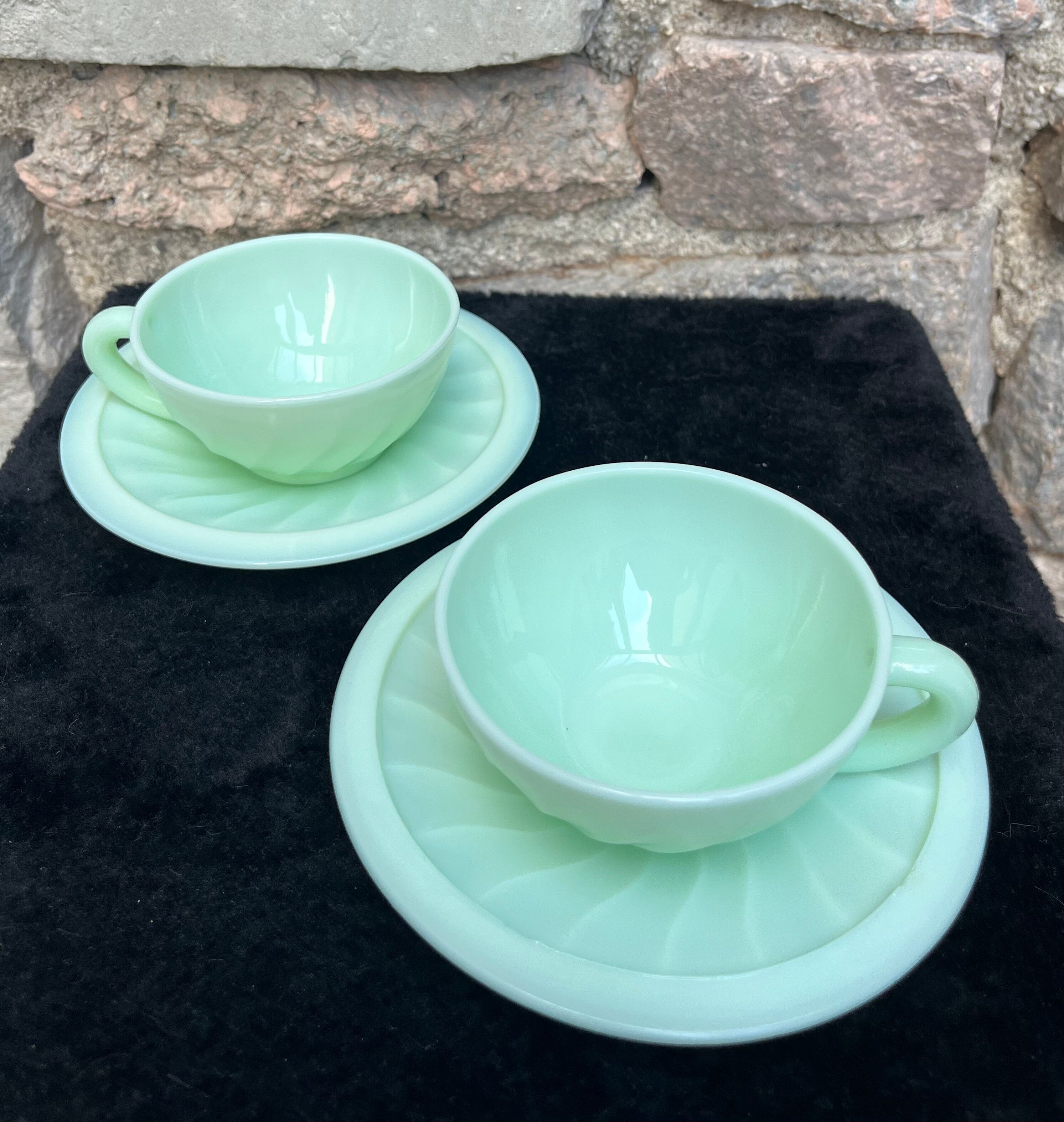 Two green opaline cup and saucer sets.