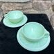 Two green opaline cup and saucer sets.