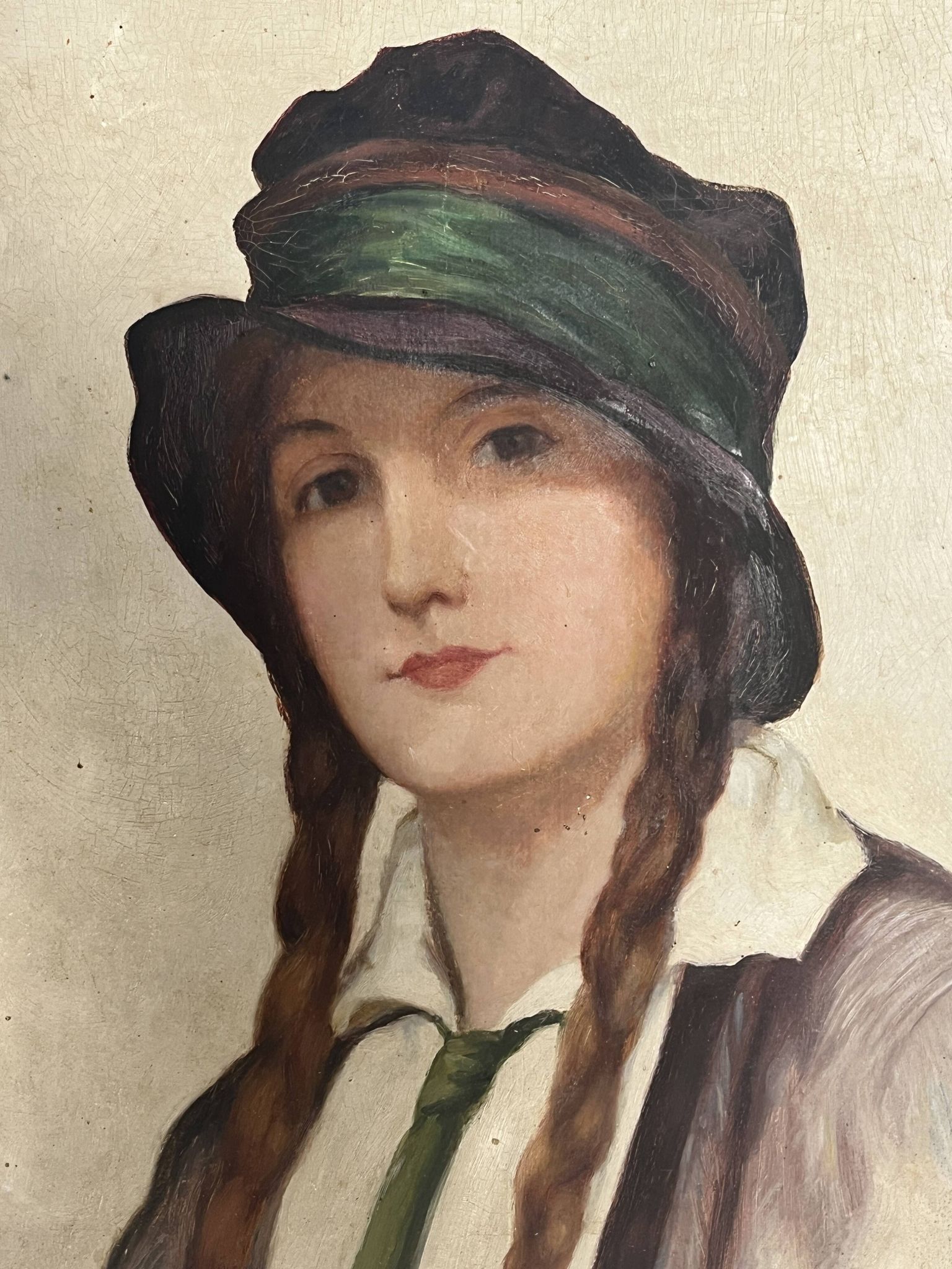 Old portrait of a young woman with braids and a hat, circa 1930