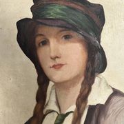 Old portrait of a young woman with braids and a hat, circa 1930