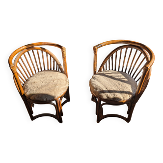 Pair of vintage rattan armchairs with soft fabric seats