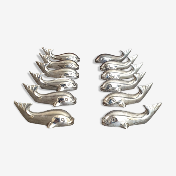 Lot 12 knife holders in the shape of a stylized whale or fish