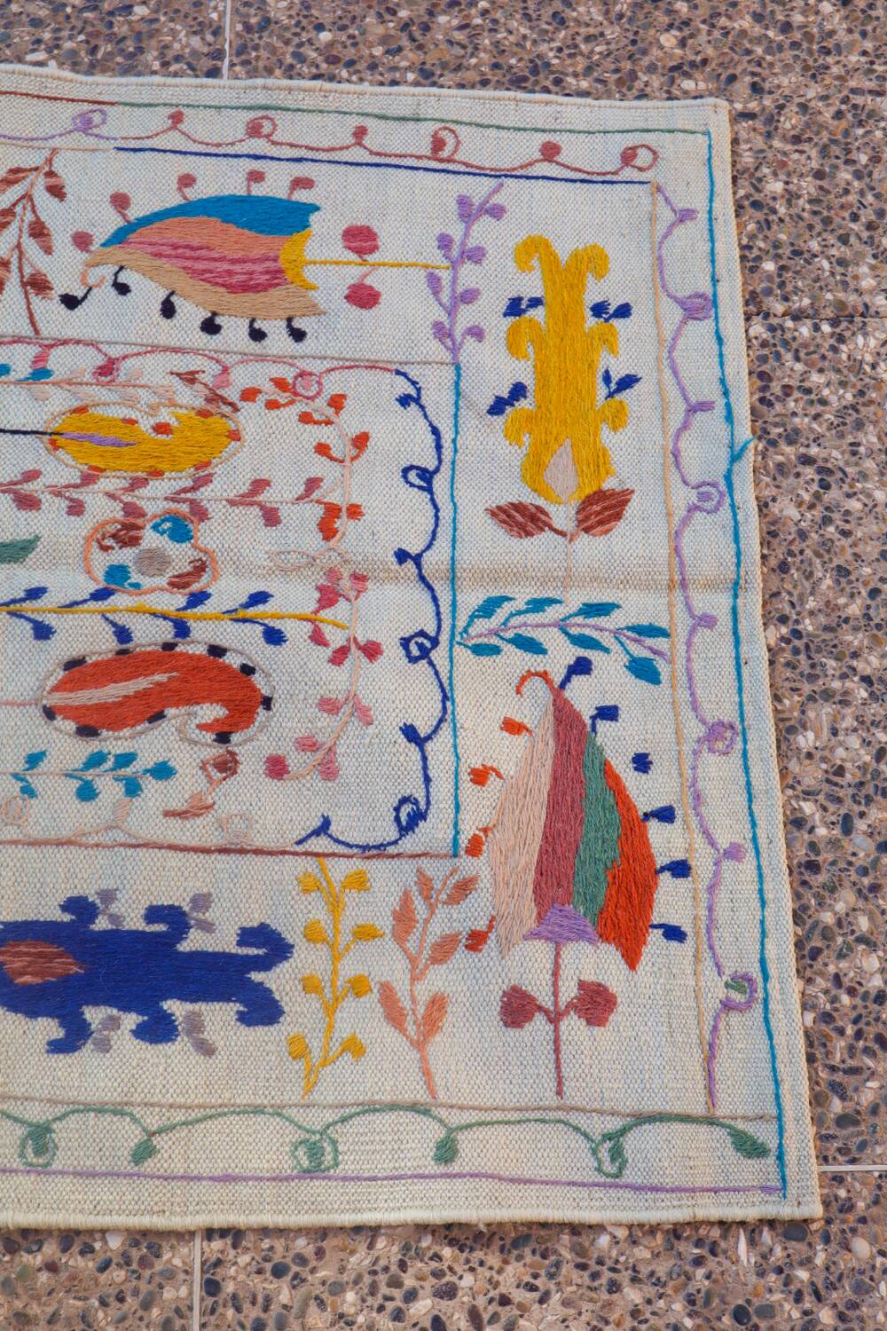 White suzani kilim rug with embroidered colorful patterns