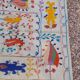 White suzani kilim rug with embroidered colorful patterns