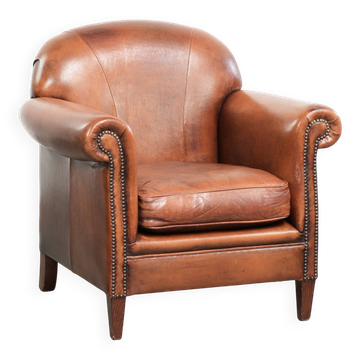 Comfortable vintage sheepskin armchair finished with decorative nails