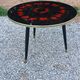 Vintage coffee table with glass top and tripod legs in blackened wood from the 1960s.