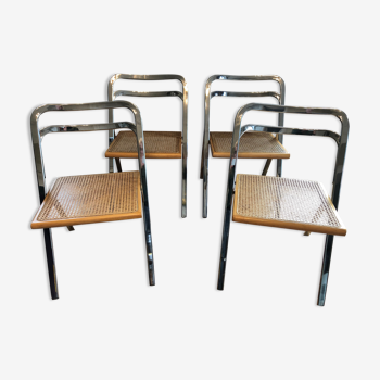 Suite de quatre chaises pliantes à structure en métal chromé et assise cannée Giorgio Cattelan