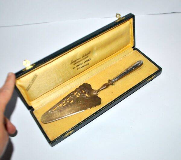 Antique silver-plated pie server with a brass blade decorated with roses.