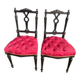 Pair of black lacquered chairs with purple tufted upholstery.