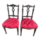 Pair of black lacquered chairs with purple tufted upholstery.