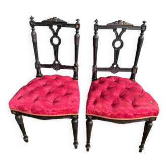Pair of black lacquered chairs with purple tufted upholstery.