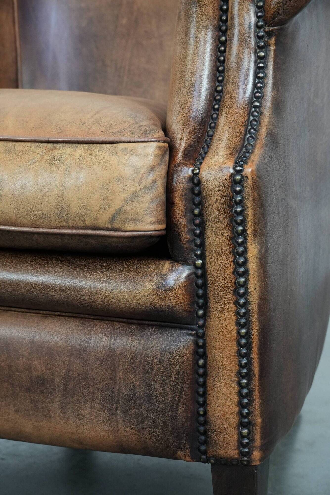 Club chair made of sheepskin leather finished with decorative nails