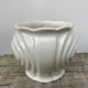 White ceramic pot cache in old flower slip