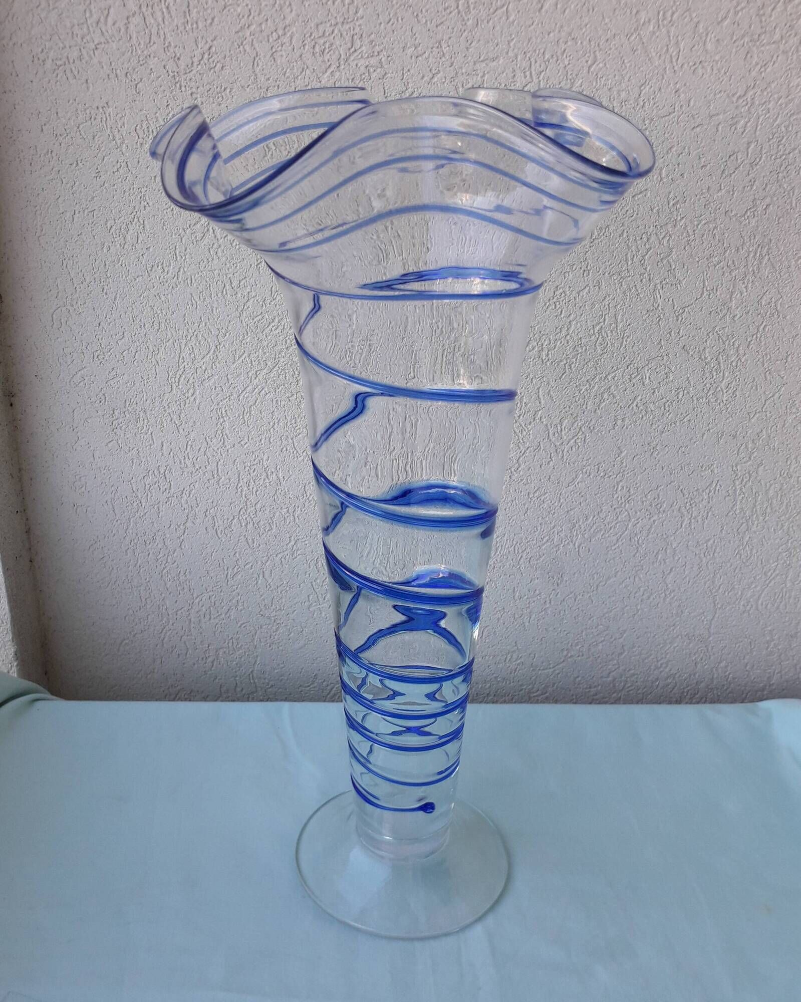 Glass vase on a pedestal with a blue trim.