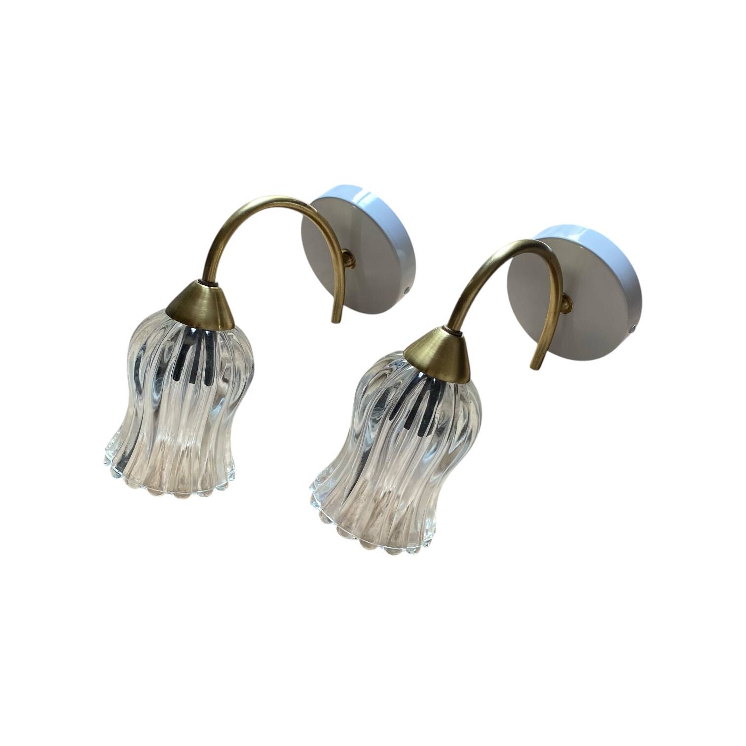 Pair of wall sconces in brass with transparent tulip glass shade.