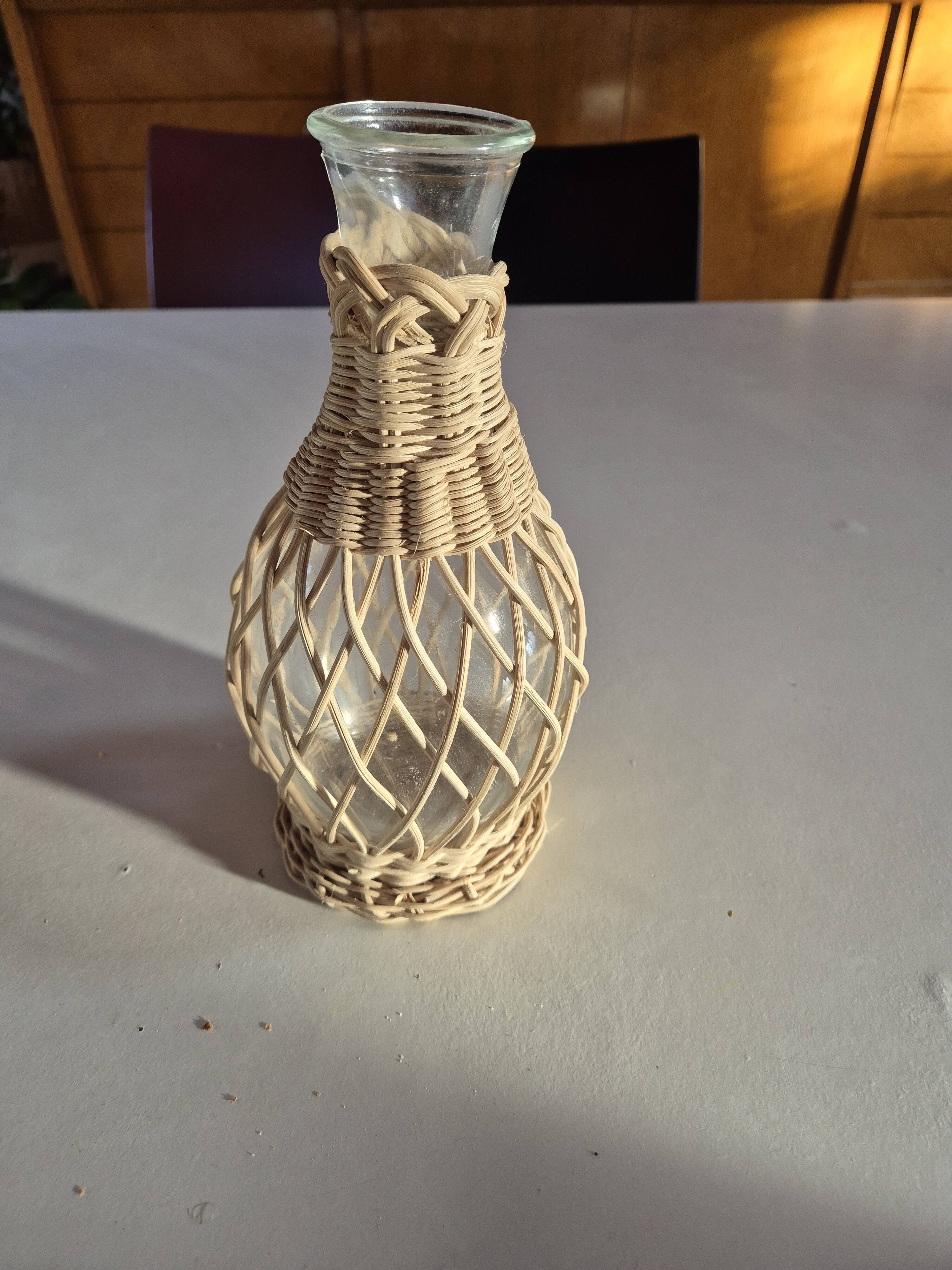 vintage glass vase surrounded by woven rattan