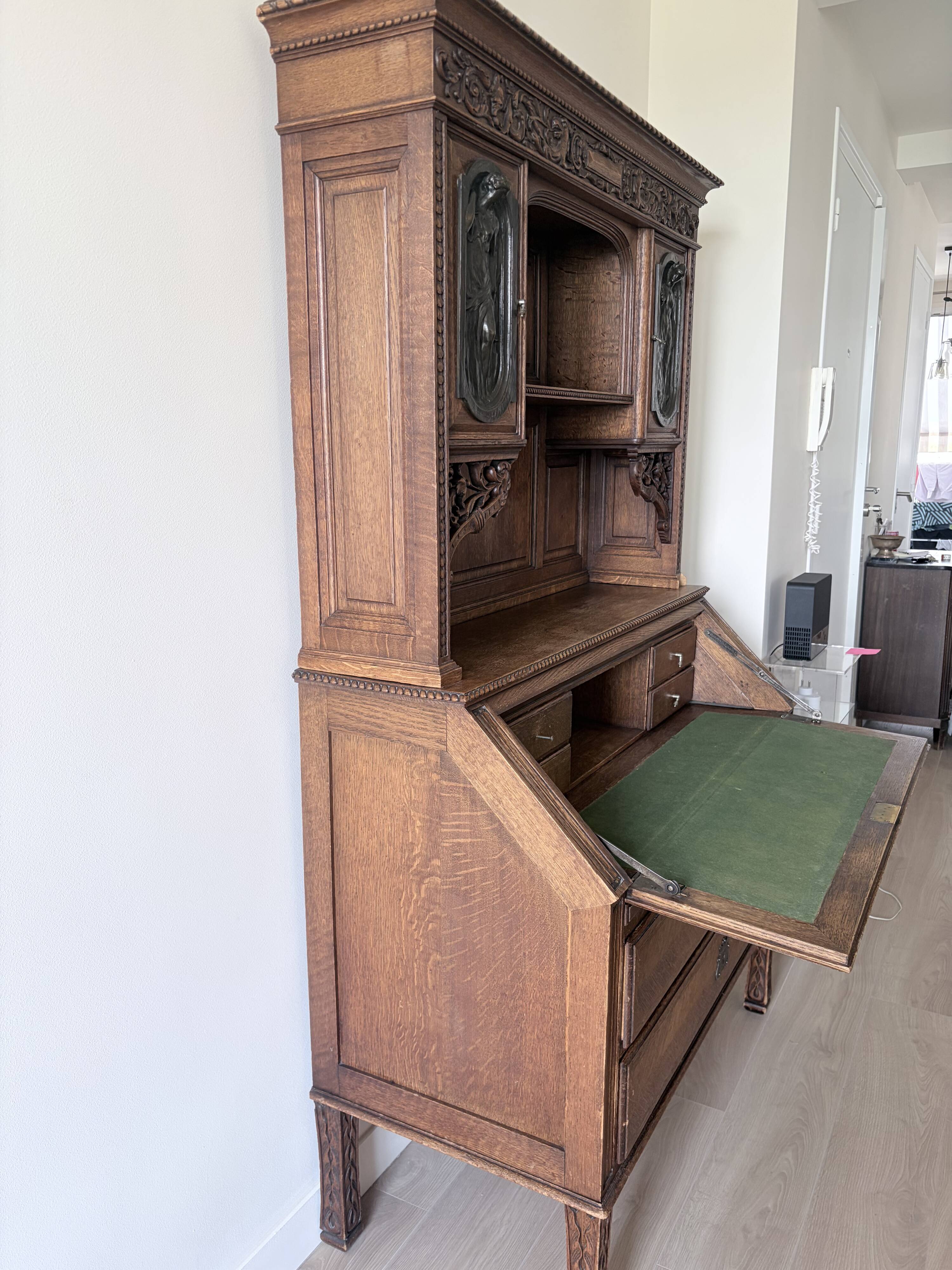 Large secretary with a drop-down front in carved oak, neo-Renaissance style.