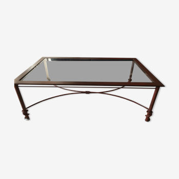 Rust-colored metal coffee table with a glass top.