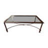 Table basse  en métal couleur rouille avec un plateau en verre.