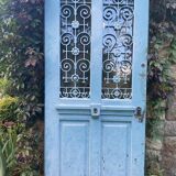 Entrance door in solid oak, cast iron grille, 1930s