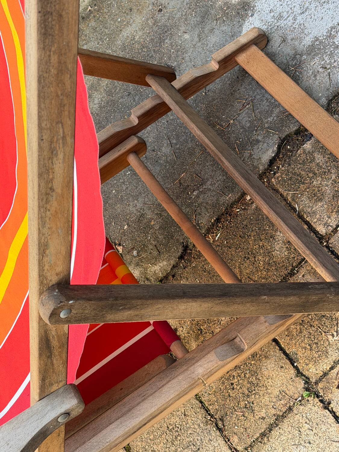 Vintage deck chair with red and orange striped fabric, original patina.